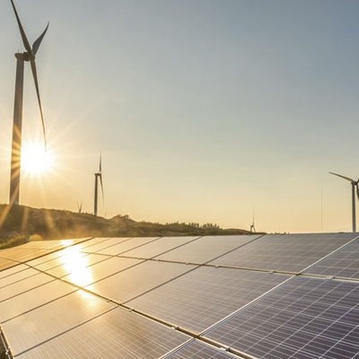 Windmills and solar panels, sunset