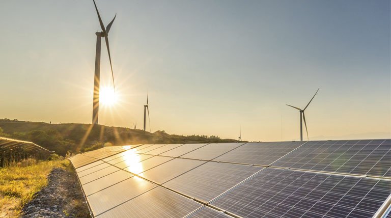 Windmills and solar panels, sunset