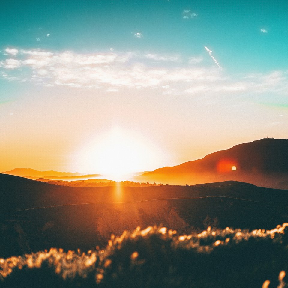Sunrise over low hills, stylized, painterly, retro feel