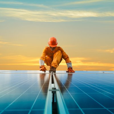 Worker in safety gear inspecting panels