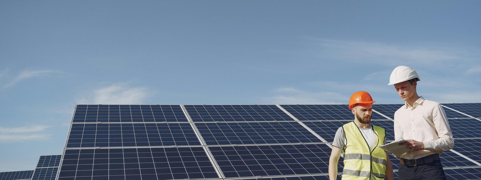 Worker reviewing papers near solar panels